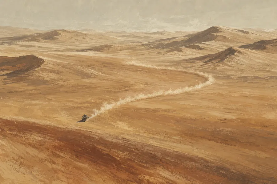 A sandbike carving a trail of dust across open sand